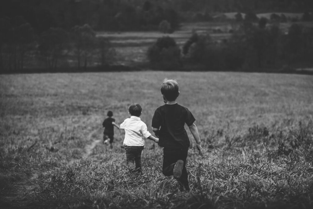 three boys running in a field